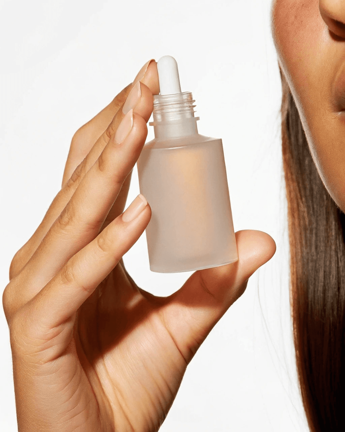 Mano sosteniendo un frasco de sérum facial